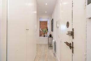 馬德里的住宿－Premium Apartment LaLatina II Renovated 3BR 3BH，走廊设有白色的墙壁和木地板