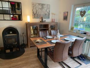 a dining room with a table and a wood stove at Ferienhaus Glückspilz beim Hennesee in Meschede