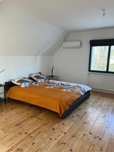 Schlafzimmer mit einem Bett und Holzboden in der Unterkunft La Corderie in Mûrs-Érigné