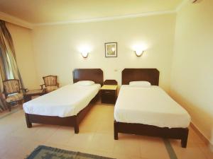 um quarto com duas camas num quarto de hotel em Regina Resort El Sokhna em Ain Sokhna