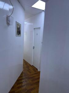 an empty hallway with a white wall and a door at Decent UNISEX Private Rooms near Burjuman Metro Exit -4 in Dubai