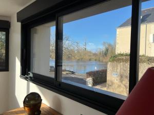a window with a view of a river at La Corderie in Mûrs-Érigné