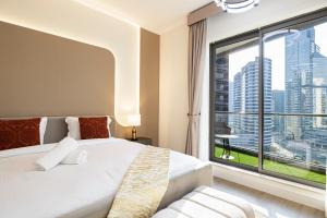 um quarto com uma cama branca e uma grande janela em Magnificent Mesmerizing 2BR Burj Khalifa View em Dubai