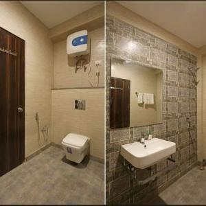 a bathroom with a sink and a toilet and a mirror at Laxmi Stay Hotel in New Delhi
