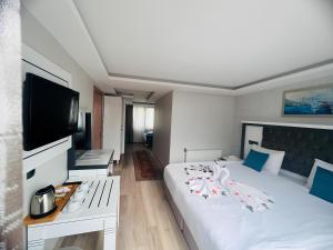 イスタンブールにあるMaritime Hotel Istanbulのベッドルーム(白い大型ベッド1台、薄型テレビ付)