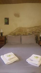 a white bed with two towels on top of it at Casa Opuntia in Pappayiannádhes