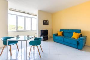 un soggiorno con divano blu e tavolo di Colli Aminei Apartment by Wonderful Italy a Napoli