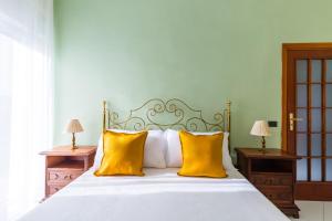 una camera da letto con un letto bianco con cuscini gialli di Colli Aminei Apartment by Wonderful Italy a Napoli