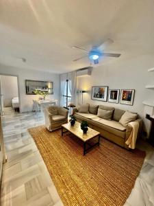 sala de estar con sofá y ventilador de techo en Apartamento En Pueblo Evita Con Piscina Y Terraza en Benalmadena Costa