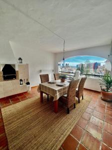 sala de estar con mesa, sillas y ventana grande en Apartamento En Pueblo Evita Con Piscina Y Terraza en Benalmadena Costa