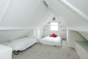 a attic bedroom with two beds and a window at Secret Seaside Retreat in Kent