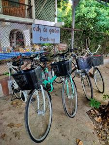 dos bicicletas estacionadas frente a un cartel de estacionamiento en Oldy De Garden en Chiang Mai