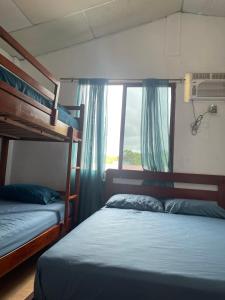 1 dormitorio con 2 literas y ventana en Cabañas Mar Olon, en Olón