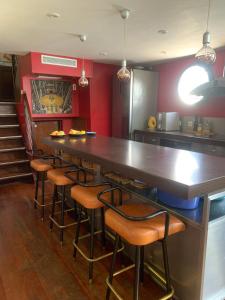 un bar con taburetes en una habitación con paredes rojas en Péniche Suresnes, en Suresnes