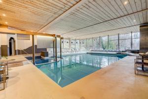 an indoor swimming pool with a large room with windows at Beausite Park Hotel & Spa in Wengen