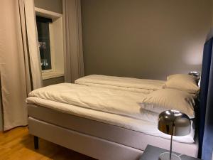 łóżko z białą pościelą i poduszkami w pokoju w obiekcie Downtown Apartment - THE VIEW w mieście Tromsø