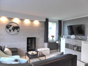 een woonkamer met een bank en een open haard bij Winterberg Cityflair Wifi Pool Sauna 6 Pers PS4 Netflix near Bikepark in Winterberg