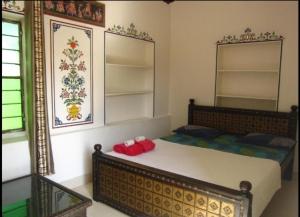 a bedroom with a large bed and a mirror at Pushkar Guest House in Pushkar