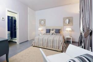 a white bedroom with a bed and a couch at Residenza Romana Zucchelli in Rome