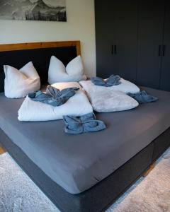 ein großes Bett mit weißen Kissen darüber in der Unterkunft Sonnige Gartenwohnung in Fritzens