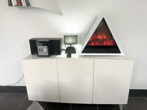 a white cabinet with a laptop on top of it at Appartement charmant à Luzenac - 60m² - Confort moderne in Luzenac +25 photos