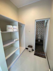 a bathroom with a walk in shower and a toilet at Hotel Bima Majalengka in Majalengka