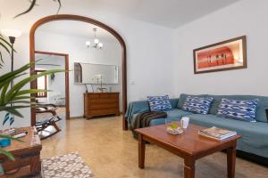 Una sala de estar con un sofá azul y una mesa. en Sunset apartment Es Celler, en Alcudia 16 fotos más