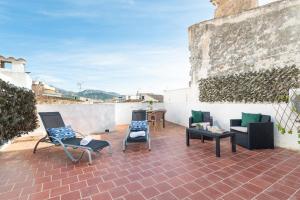 een patio met stoelen en een tafel op een bakstenen vloer bij Sunset apartment Es Celler in Alcudia