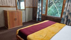 a bedroom with a bed and a cabinet and a window at Phoenix Hotel & Restaurant in Kota Bāgh