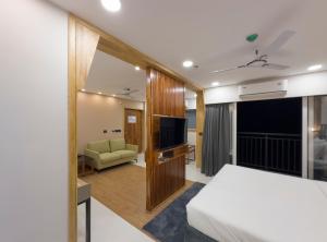 een hotelkamer met een bed en een televisie bij The Habitat Suites in Guruvāyūr