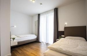 Un dormitorio con dos camas y una gran ventana. en Ferienwohnung 1-24 im Deichhaus 1, en Wohlendorf 5 fotos más