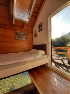 a bed in a room with a large window at Vacation Home Pliva in Šipovo