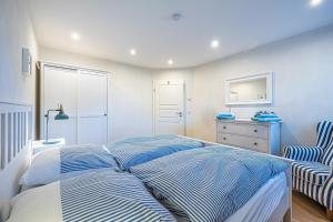 a bedroom with a bed with blue and white stripes at Ferienwohnung Luv in Gelting