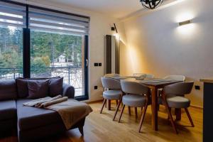 a living room with a couch and a table with chairs at Winter House TT Jahorina in Jahorina