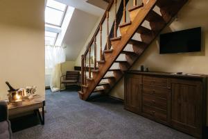 a living room with a staircase with a flat screen tv at Jaunmoku Palace Complex Hotel in Tume