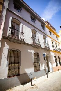 un edificio blanco con puertas y balcones en Hostal San Francisco, en Sevilla
