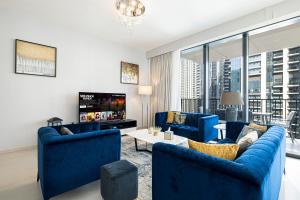 a living room with blue couches and a tv at Magnificent Cozy 2BR in Downtown Dubai in Dubai
