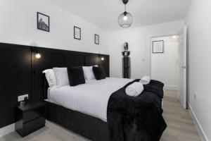 Orange Rentals- Apartment close to Anfield- sleeps 6 guests- Free Parking! في ليفربول: غرفة نوم بسرير كبير عليها منشفتين