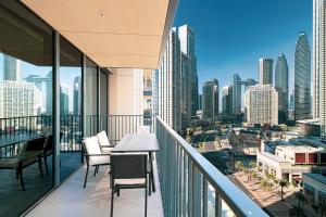 een balkon met een tafel en stoelen en een skyline van de stad bij Magnificent Cozy 2BR in Downtown Dubai in Dubai
