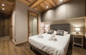 a bedroom with a large bed with white sheets and pillows at A brand new apartment in a calm environment in Praz-sur-Arly