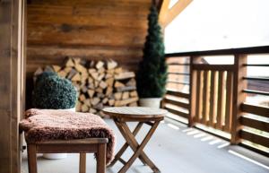 a room with a chair and a table and logs at A brand new apartment in a calm environment in Praz-sur-Arly