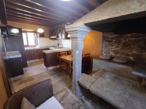 a kitchen with a table and a stone fireplace at Grupo Gontad A Vixia do Roncudo in A Coruña