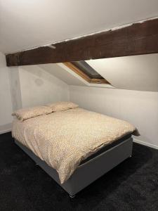 ein Schlafzimmer mit einem Bett in einem Zimmer mit einem Dach in der Unterkunft Victor's House in Huddersfield