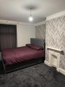 a bedroom with a bed and a fireplace in it at Victor's House in Huddersfield