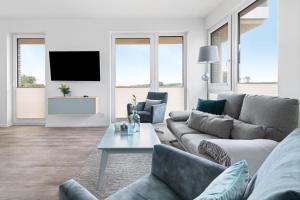 uma sala de estar com um sofá e uma mesa em BeachTerraceOne - EG, Meerblick, Terrasse, Kamin, Sauna em Olpenitz
