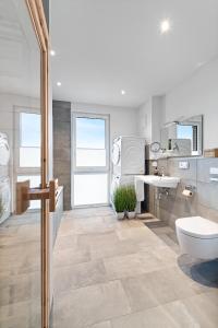 een badkamer met een toilet en een wastafel bij BeachTerraceOne - EG, Meerblick, Terrasse, Kamin, Sauna in Olpenitz