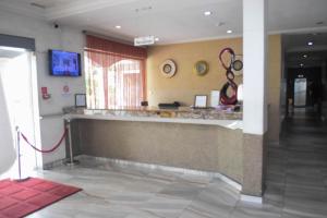 a lobby with a counter with a red hose at Golden Tulip Hotel -GT31 Stadium Road in Port Harcourt