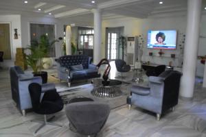 ポートハーコートにあるGolden Tulip Hotel -GT31 Stadium Roadのソファ、椅子、薄型テレビが備わるロビー