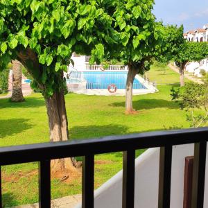 a balcony with a view of a park with trees at Apartamento en Son Bou cerca de la playa in Son Bou