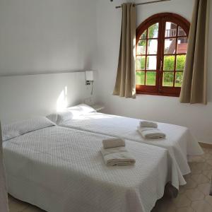 a bedroom with a white bed with towels on it at Apartamento en Son Bou cerca de la playa in Son Bou